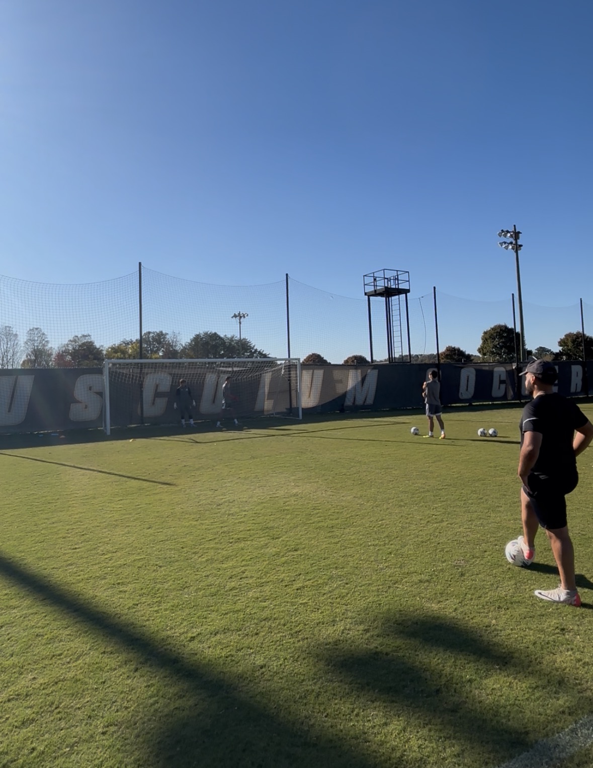 Professional goalkeeper in yellow jersey making an athletic diving save, demonstrating elite goalkeeper training techniques